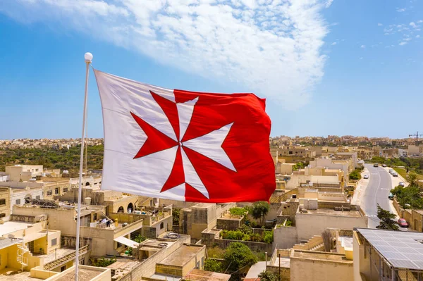 Malta bayrağı ve çatıda çapraz geçiş. Mavi gökyüzü. Gozo Adası, Malta ülkesi