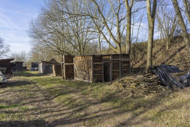 Testere, kırık odun, çayırda yatan sandıklar..