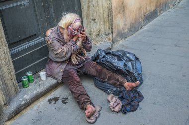 Roma - 18 Haziran 2014: Evsiz bir kadın bira içiyor ve makyaj yapıyor.
