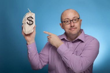Kazıklı gömlekli bir işadamı, dolar dolu bir çuvalda işaret parmağıyla işaret ediyor.