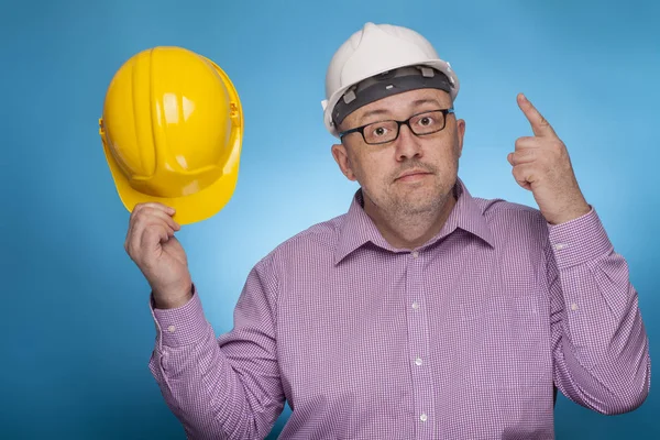 Un homme d'affaires, architecte dans une chemise piquée pointant avec l'index sur le casque blanc — Photo