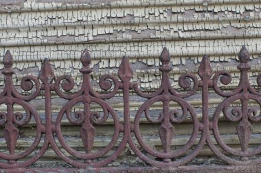 Ahşap cephede eski, parçalanmış boya. Eski yıpranmış bir çit.