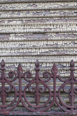 Ahşap cephede eski, parçalanmış boya. Eski yıpranmış bir çit.