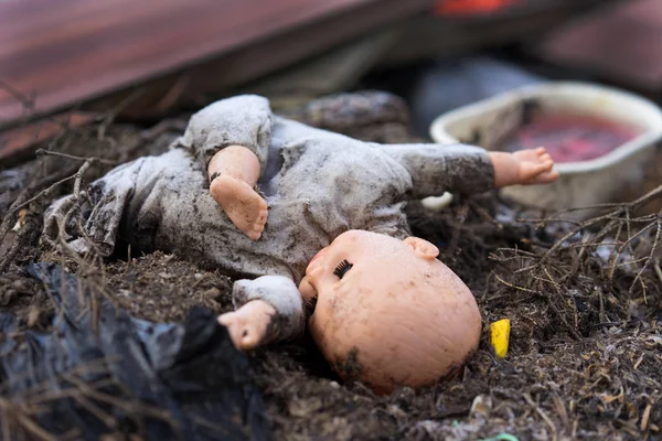 Vecchia bambola sporca su un terreno bruciato Fotografia Stock