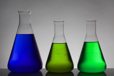 Laboratuvar şişelerinde sıvı. Bilimsel biyokimya laboratuvarı. Renkli sıvı.