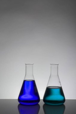 Laboratuvar şişelerinde sıvı. Bilimsel biyokimya laboratuvarı. Renkli sıvı.