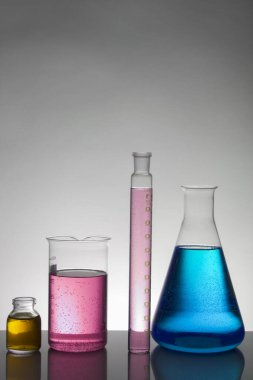 Laboratuvar şişelerinde sıvı. Bilimsel biyokimya laboratuvarı. Renkli sıvı.