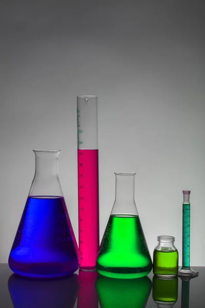 Vätska i laboratorieflaskor. Vetenskapligt biokemiskt laboratorium. Färgglad vätska. — Stockfoto