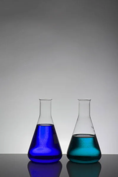 Laboratuvar şişelerinde sıvı. Bilimsel biyokimya laboratuvarı. Renkli sıvı.