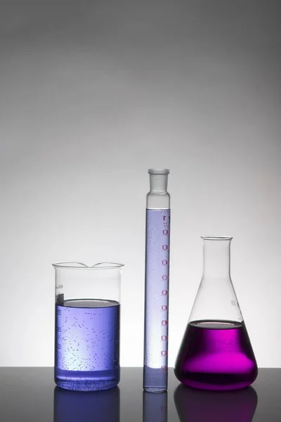 Laboratuvar şişelerinde sıvı. Bilimsel biyokimya laboratuvarı. Renkli sıvı.