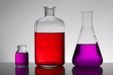 Laboratuvar şişelerinde sıvı. Bilimsel biyokimya laboratuvarı. Renkli sıvı.