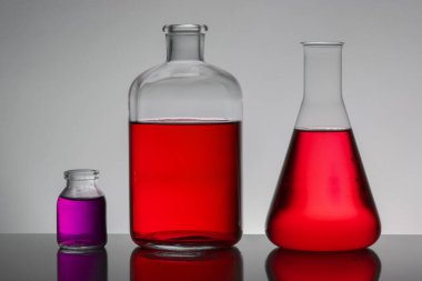 Laboratuvar şişelerinde sıvı. Bilimsel biyokimya laboratuvarı. Renkli sıvı.