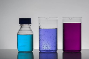 Laboratuvar şişelerinde sıvı. Bilimsel biyokimya laboratuvarı. Renkli sıvı.