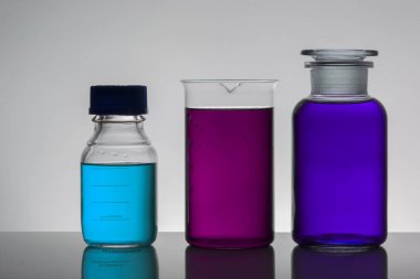 Laboratuvar şişelerinde sıvı. Bilimsel biyokimya laboratuvarı. Renkli sıvı.