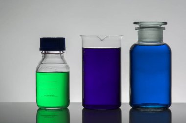 Laboratuvar şişelerinde sıvı. Bilimsel biyokimya laboratuvarı. Renkli sıvı.