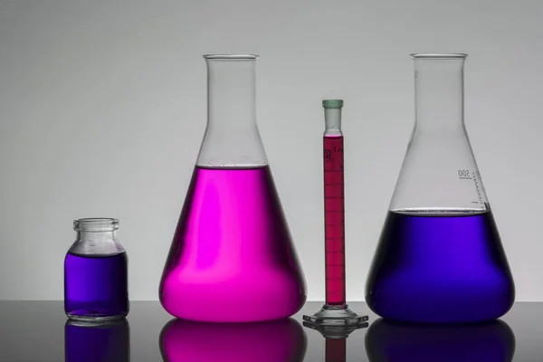 Liquide dans des bouteilles de laboratoire. Laboratoire biochimique scientifique. Liquide coloré . — Photo