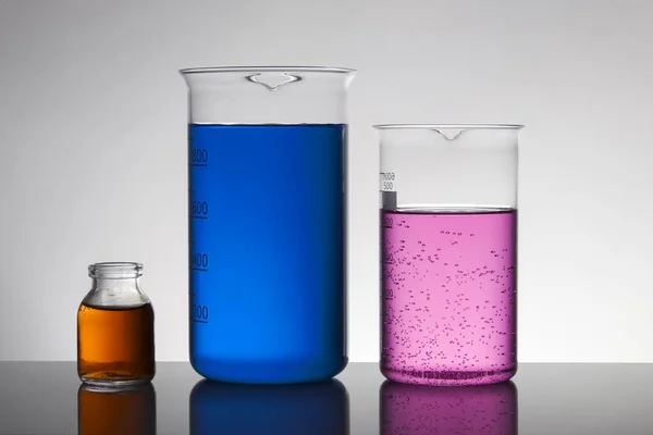 Laboratuvar şişelerinde sıvı. Bilimsel biyokimya laboratuvarı. Renkli sıvı.