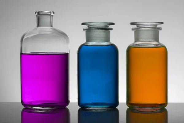 Liquido in bottiglie da laboratorio. Laboratorio biochimico scientifico. Liquido colorato . — Foto Stock