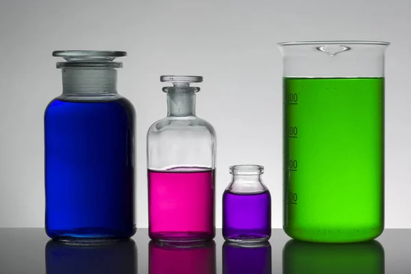 Liquide dans des bouteilles de laboratoire. Laboratoire biochimique scientifique. Liquide coloré . — Photo