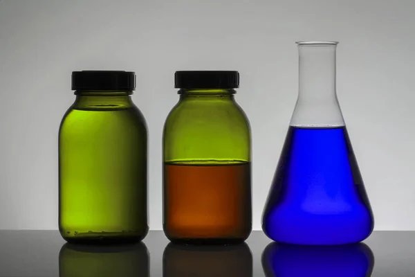 Liquide dans des bouteilles de laboratoire. Laboratoire biochimique scientifique. Liquide coloré . — Photo