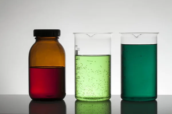 Vätska i laboratorieflaskor. Vetenskapligt biokemiskt laboratorium. Färgglad vätska. — Stockfoto