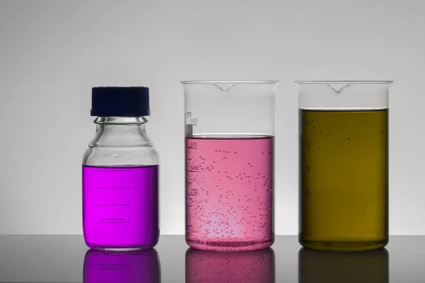 Liquide dans des bouteilles de laboratoire. Laboratoire biochimique scientifique. Liquide coloré . — Photo