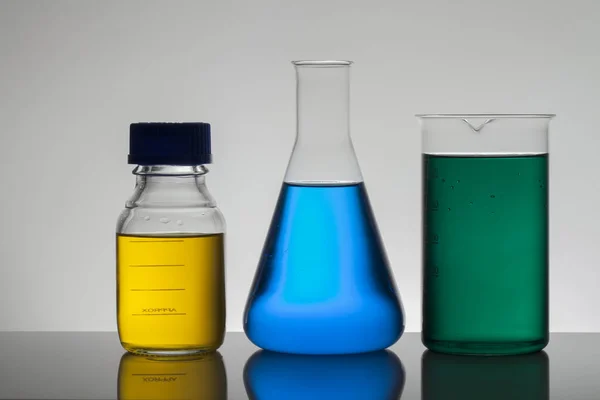 Liquide dans des bouteilles de laboratoire. Laboratoire biochimique scientifique. Liquide coloré . — Photo