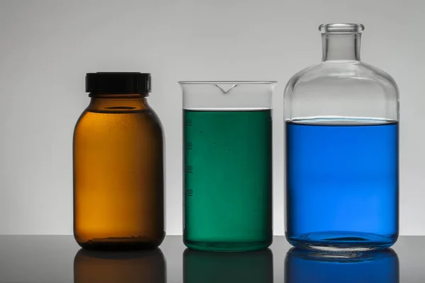 Vloeibaar in laboratoriumflessen. Wetenschappelijk biochemisch laboratorium. Kleurrijke vloeistof. — Stockfoto