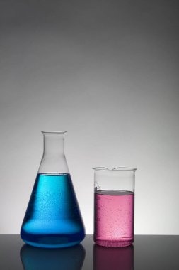 Laboratuvar şişelerinde sıvı. Bilimsel biyokimya laboratuvarı. Renkli sıvı.