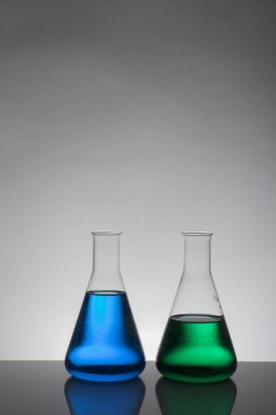Laboratuvar şişelerinde sıvı. Bilimsel biyokimya laboratuvarı. Renkli sıvı.