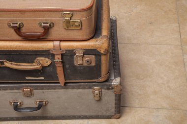 Eski, eski, beyaz arka planlı bavullar masanın üzerinde.