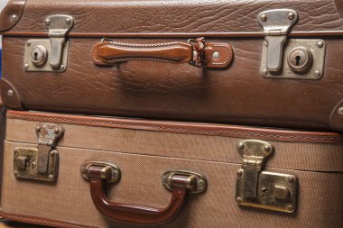 Eski, eski, beyaz arka planlı bavullar masanın üzerinde.