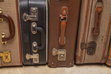 Eski, eski, beyaz arka planlı bavullar masanın üzerinde.