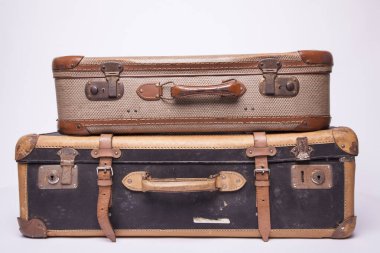 Eski, eski, beyaz arka planlı bavullar masanın üzerinde.