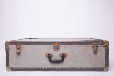 Eski, eski, beyaz arka planlı bavullar masanın üzerinde.