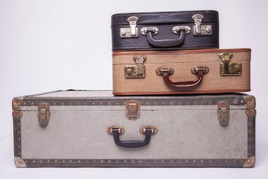 Eski, eski, beyaz arka planlı bavullar masanın üzerinde.