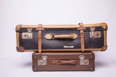 Eski, eski, beyaz arka planlı bavullar masanın üzerinde.