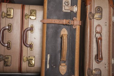 Eski, eski, beyaz arka planlı bavullar masanın üzerinde.