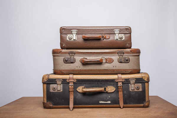 Старые, ретро, чемоданы лежат на столе с белым фоном
