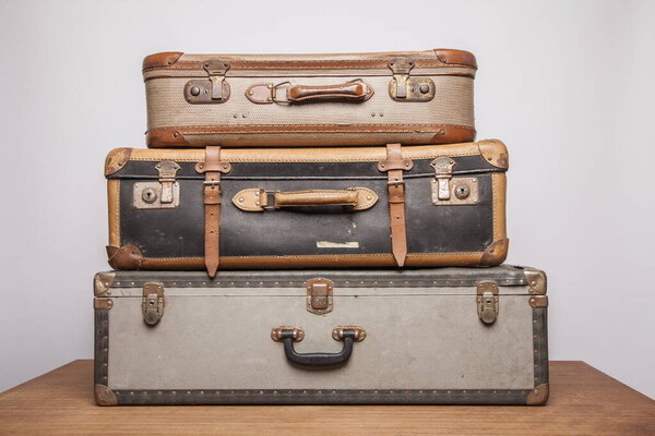 Старые, ретро, чемоданы лежат на столе с белым фоном
