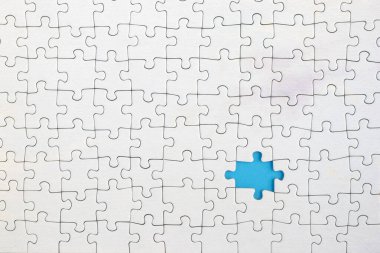 Beyaz yapbozdaki kayıp parçayı gösteren mavi arkaplan.