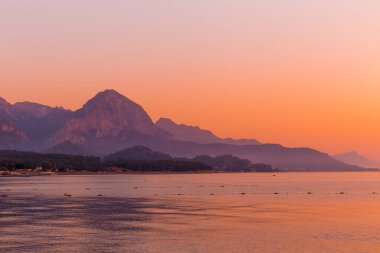 Summer morning on the sea coast surrounded by mountains