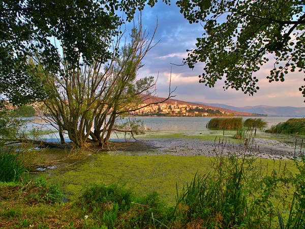 Lago Orestiada e cidade de Kastoria na hora do pôr do sol, sob sk nublado — Fotografia de Stock