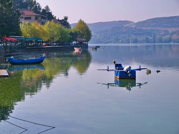 Lago Orestiada, Kastoria Grecia. Reflejos de barco, tierra y h — Foto de Stock