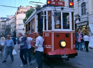 İkonik kırmızı tramvay üzerinde asılı duran bir kadın. 