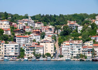 Boğaz kıyısındaki yatlar ve konut binaları tırmanıyor.