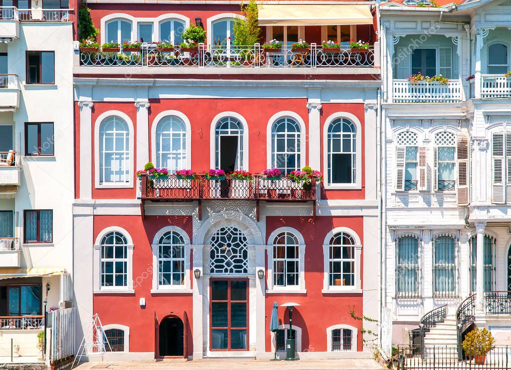 Colorful red mansion  with arched windows and beautiful balconie