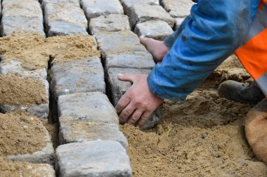 Bir işçi kaldırım taşları serer