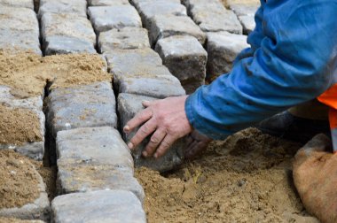 Bir işçi kaldırım taşları serer