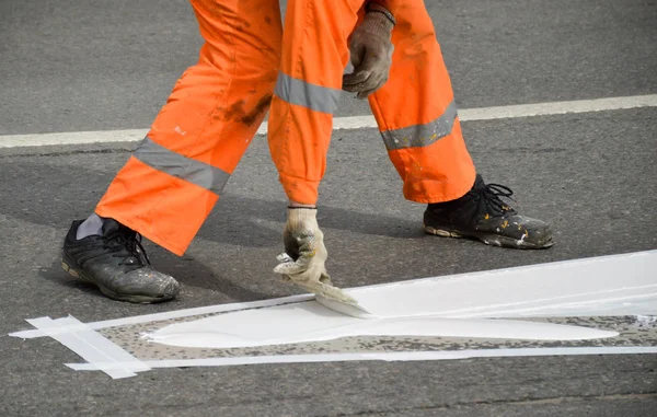 Road worker marking up with white paint
